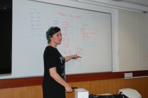 Tara Copplestone is shown in front of a white board.